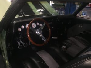 Classic muscle car interior restoration with custom gauges and steering wheel